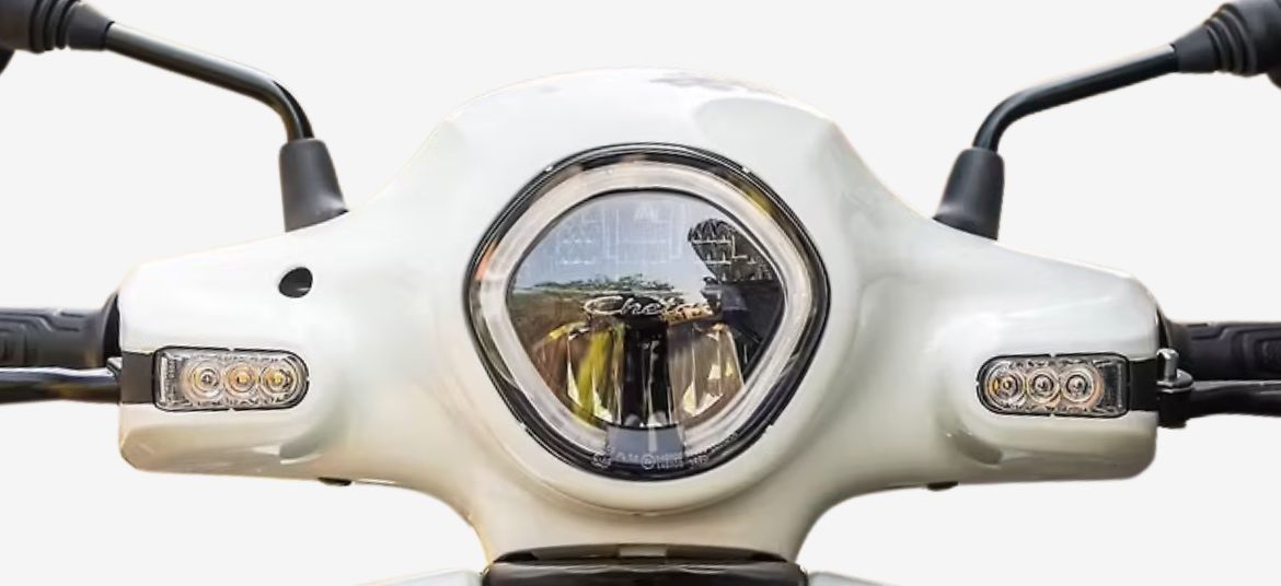 Classic round LED headlamp of Bajaj Chetak C2501 electric scooter with turn indicators.